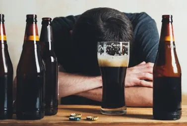 мужчина за столом с бутылками пива