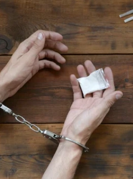 руки в наручниках с пакетом наркотиков &mdash; признаки наркомании